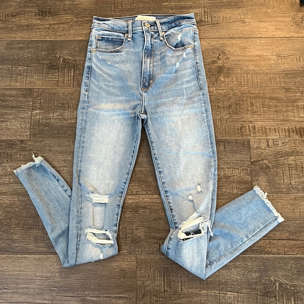 Light blue high waisted skinny jeans, ripped at knee level